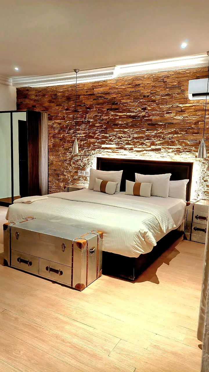 King Room with Balcony category with a made bed and bedside table